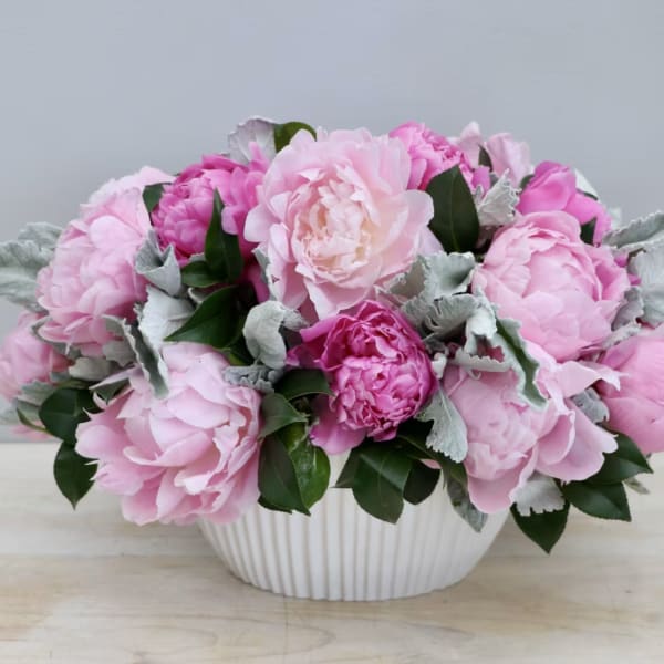 Pink peony bouquet in a white ribbed bowl vase