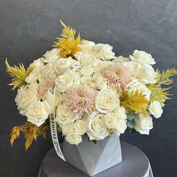 White rose bouquet with pale pink blooms in a gray vase