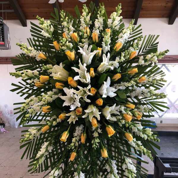 Large standing floral spray with white lilies and yellow roses