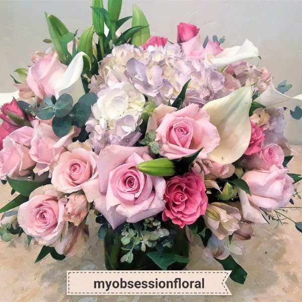Pink roses and white calla lilies arranged with pale hydrangeas