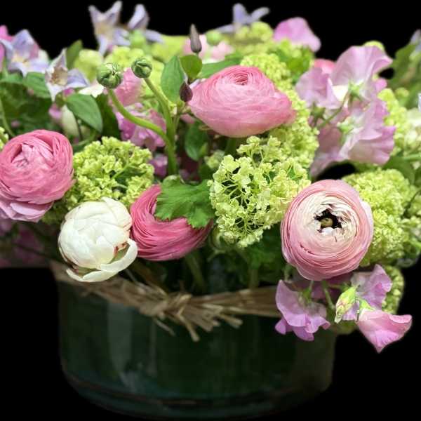 Pink and white flowers arranged in a green vase