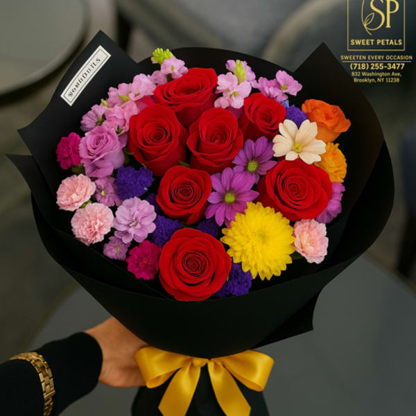 Bouquet of red roses and mixed colorful flowers wrapped in black paper