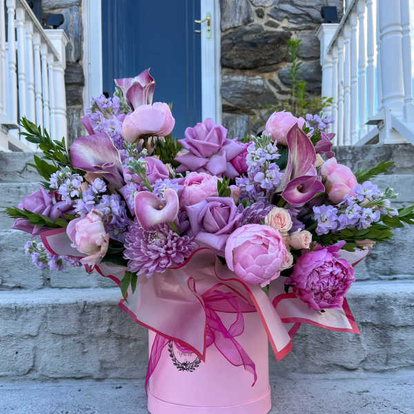 Pink and lavender bouquet in a pink hatbox with ribbon