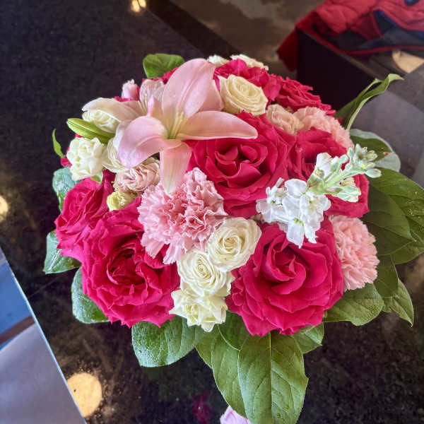 Pink and white rose bouquet with a pale lily and carnations