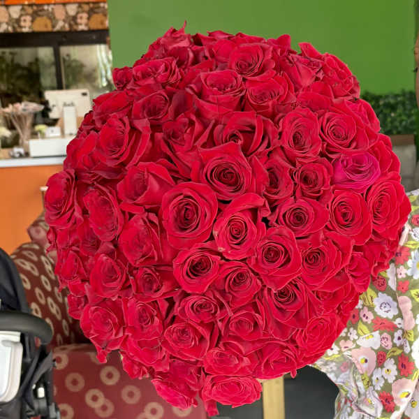 Large bouquet of red roses held indoors