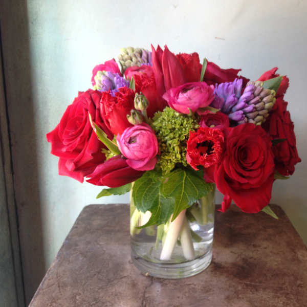 Red and pink flowers arranged in a clear glass vase