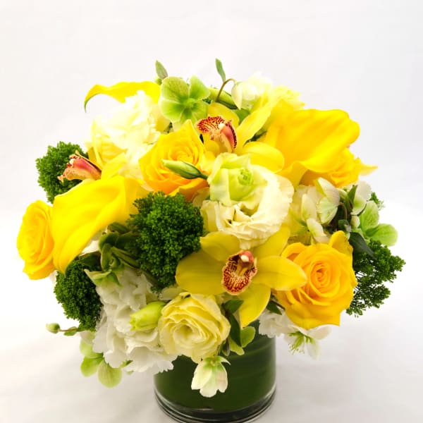 Yellow and white floral arrangement in a glass vase