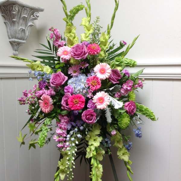 Tall floral spray with pink and purple blooms on an easel