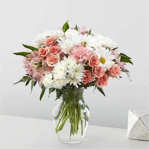 Pink roses and white daisies in a clear glass vase