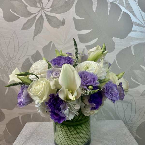 Purple and white bouquet in a glass vase