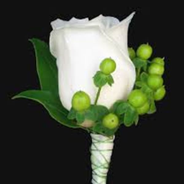White rose boutonniere with green berries and leaves