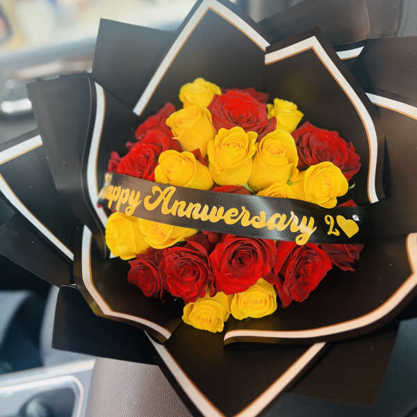 Bouquet of red and yellow roses wrapped in black paper