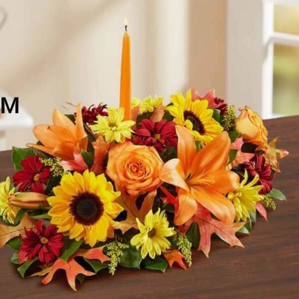 Autumn floral centerpiece with a tall orange candle