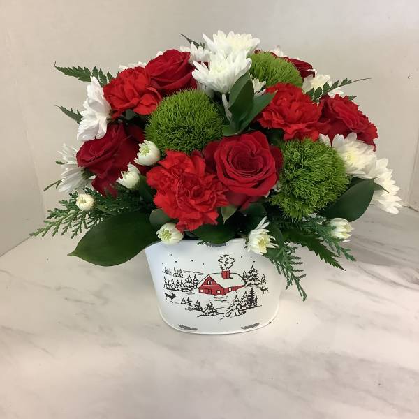 Red and white flower arrangement in a white holiday tin