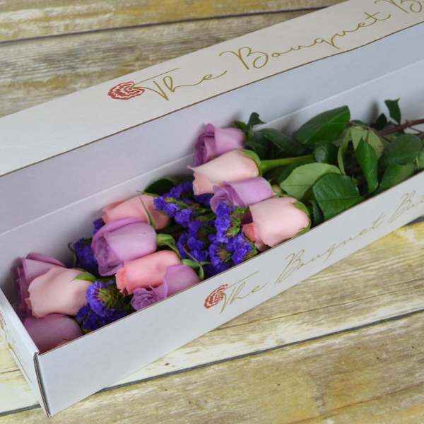 Pink and lavender roses in a white gift box