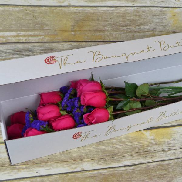 Boxed bouquet of pink roses with purple filler flowers