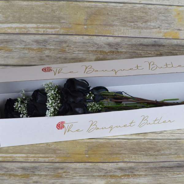 Black roses in a white bouquet box with baby's breath