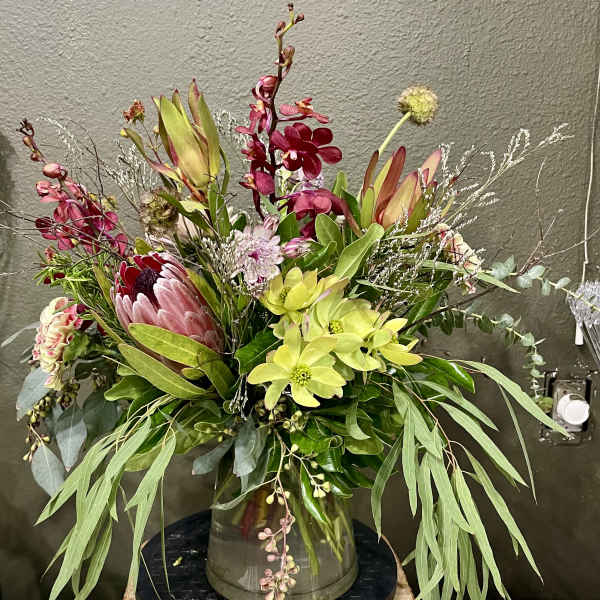 Mixed bouquet with pink and green flowers in a glass vase