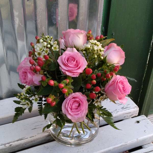 Pink roses arranged in a clear glass vase
