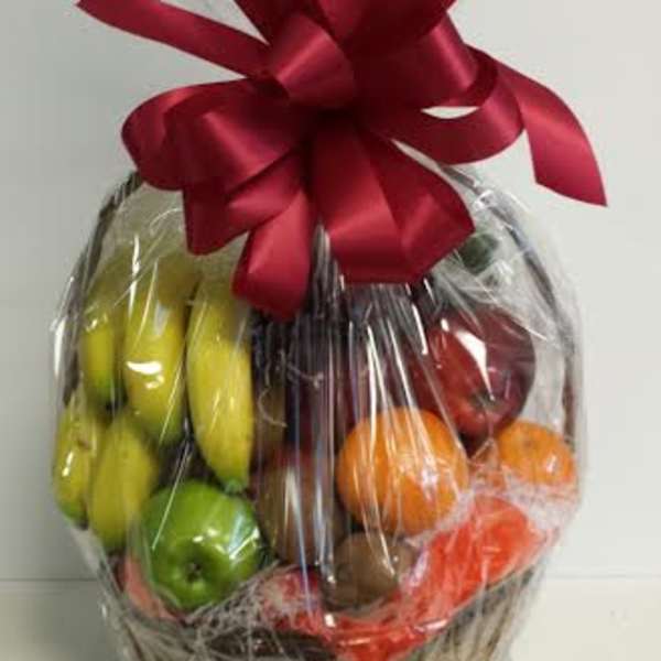 Basket of assorted fruit wrapped in cellophane with a red bow