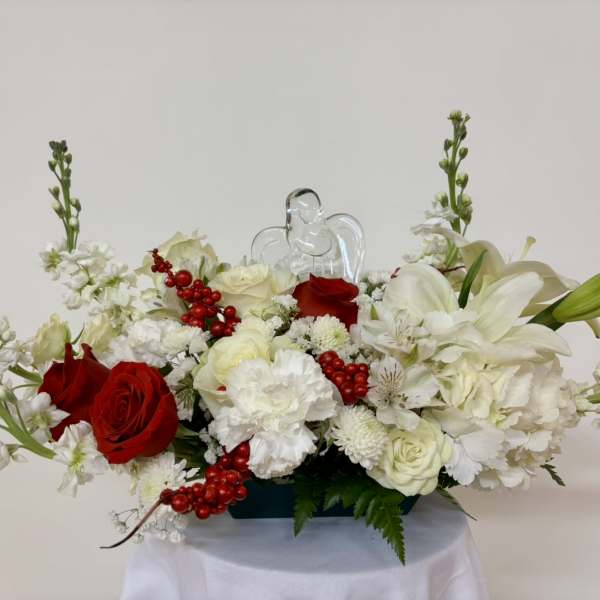 Red and white floral arrangement with a clear angel figurine
