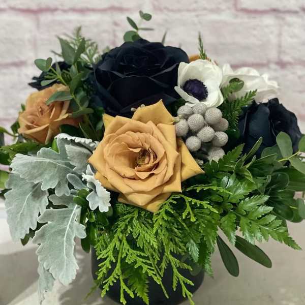 Bouquet of dark and peach roses with white anemones in a black vase