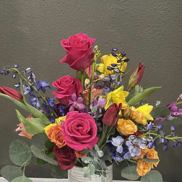 Colorful mixed bouquet in a white vase with roses and tulips