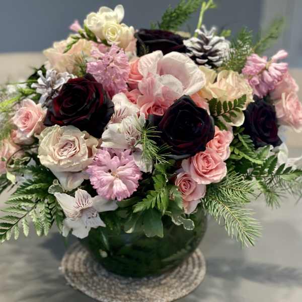 Mixed pink and white flowers in a green glass vase