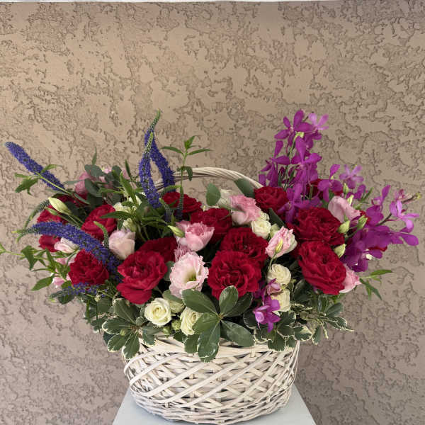 Basket arrangement of red and pink roses with purple orchids