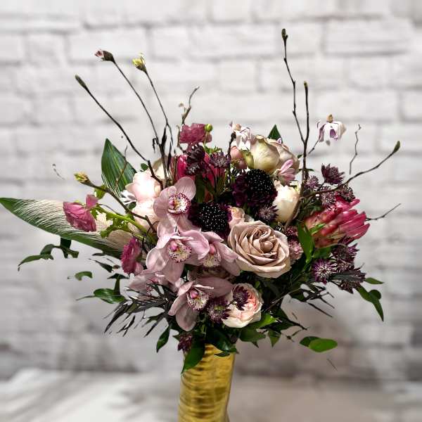 Mixed pink and cream floral arrangement in a gold vase