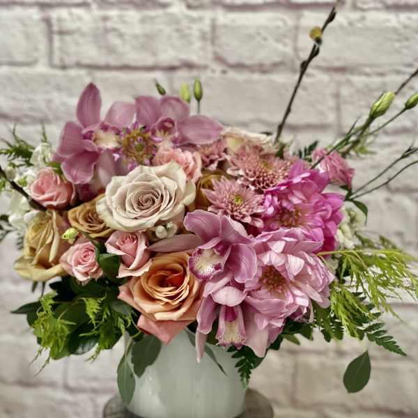 Pink and peach mixed flower arrangement in a white vase