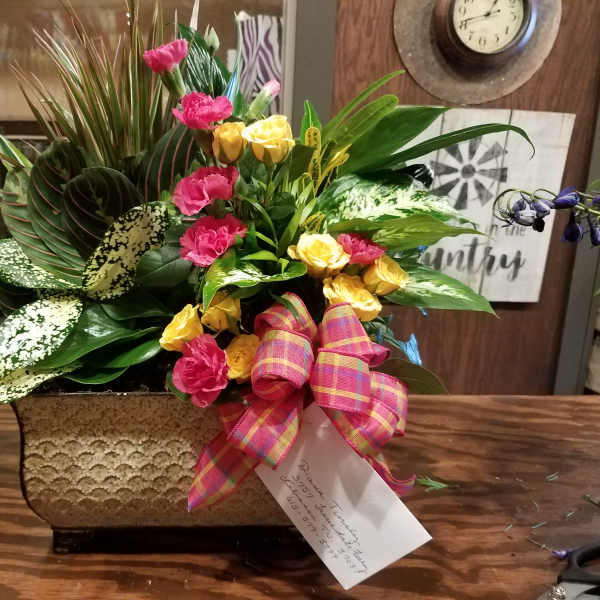 Mixed floral arrangement in a textured rectangular container with a plaid ribbon