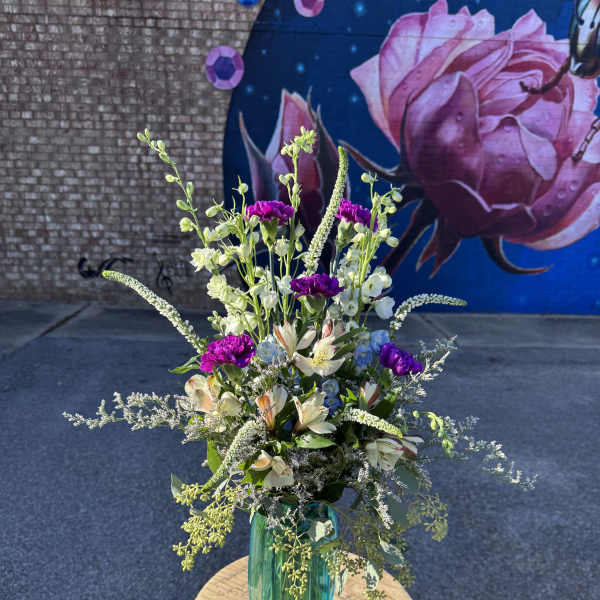 Tall mixed bouquet in a teal glass vase with pink and white blooms