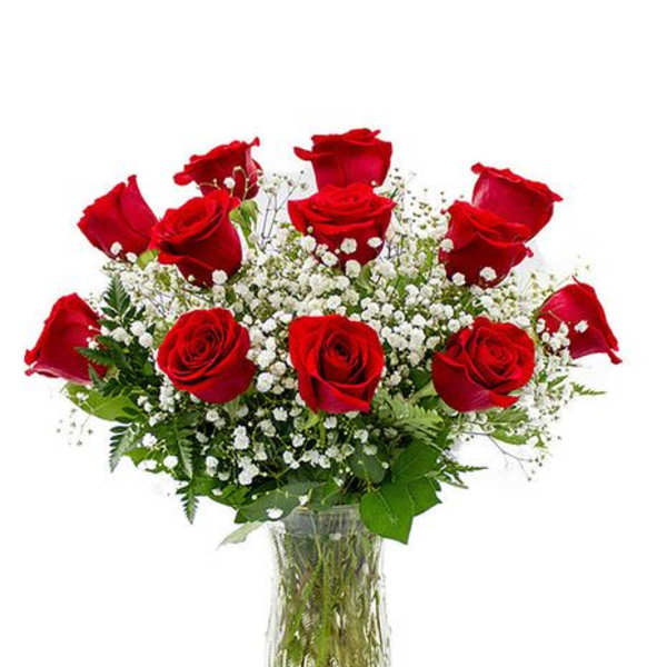 Red roses arranged in a clear glass vase with white baby's breath