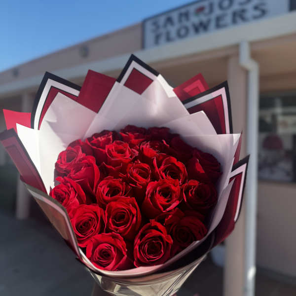 Bouquet of red roses wrapped in white and black paper