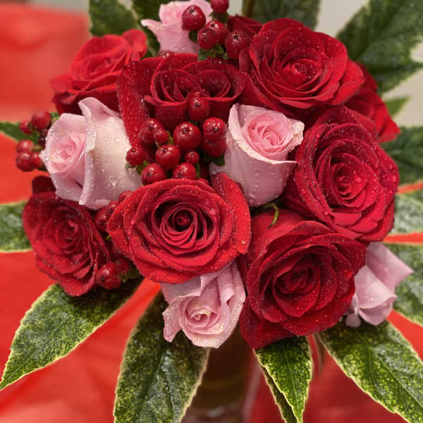 Bouquet of red and pink roses with berry accents