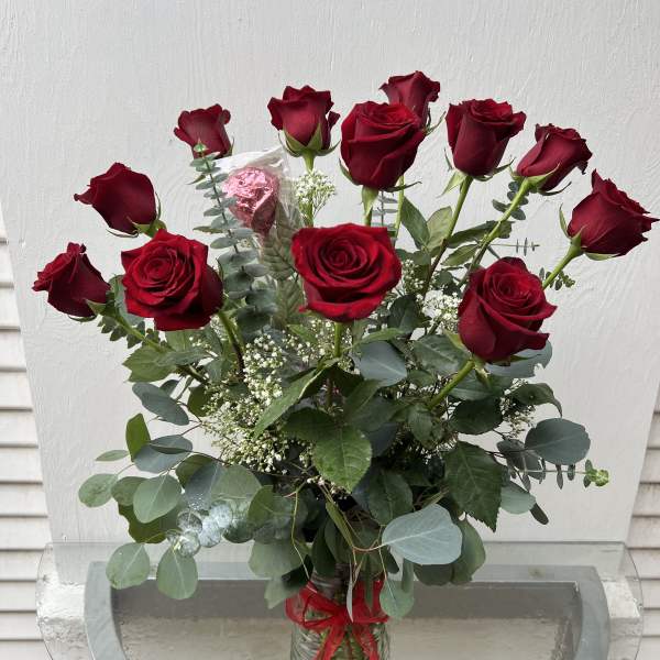 Bouquet of red roses in a glass vase with a red ribbon