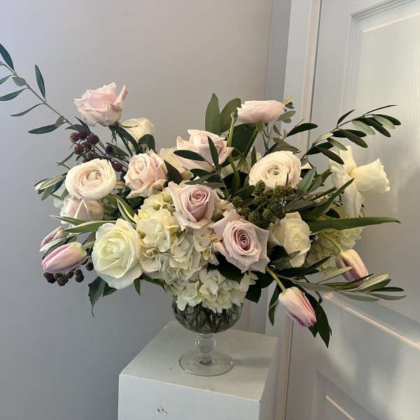 Blush and white roses with tulips in a clear glass vase