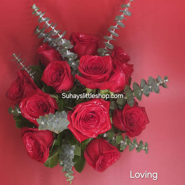 Bouquet of red roses with eucalyptus on a pink background