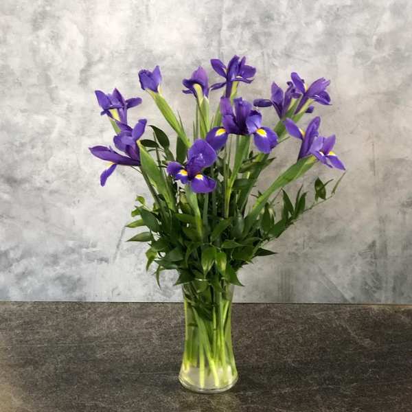 Purple iris bouquet in a clear glass vase
