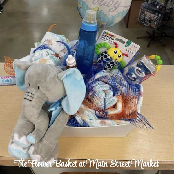 Baby gift basket with a plush elephant, balloon, and assorted infant items