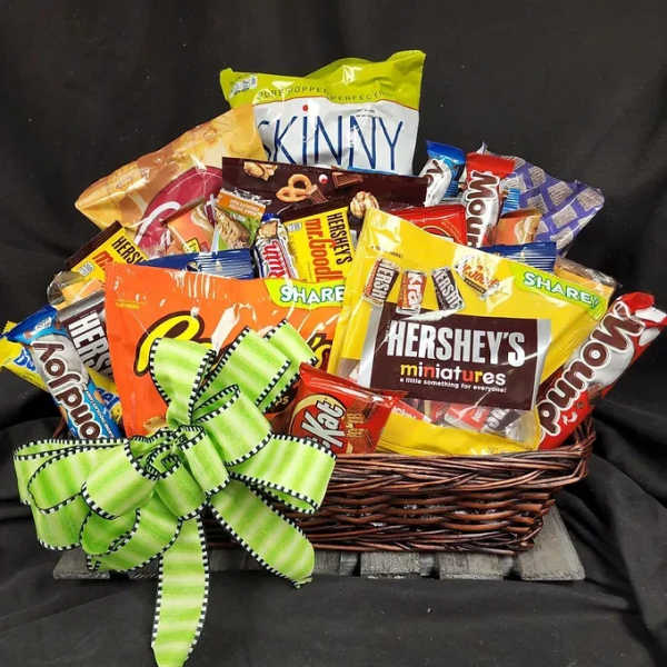 Basket filled with assorted candy bags and a green ribbon bow
