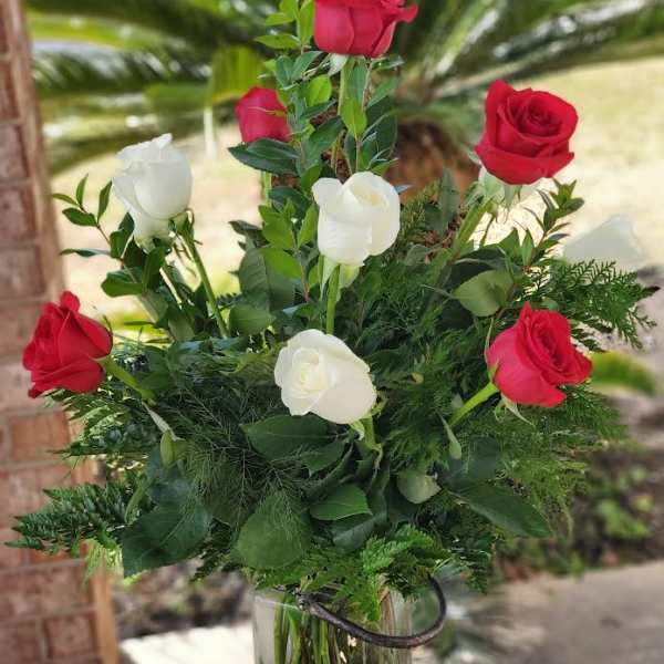 Red and white roses arranged in a clear glass vase
