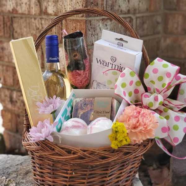 Gift basket with wine, chocolates, bath items, and flowers