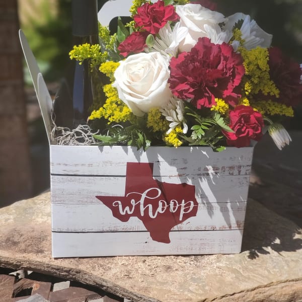 Flowers and a wine bottle in a white wooden gift box