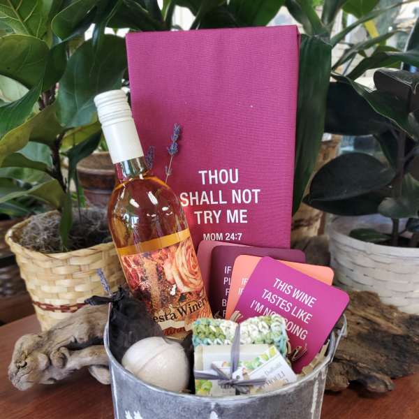 Gift basket with a wine bottle, cards, and small bath items
