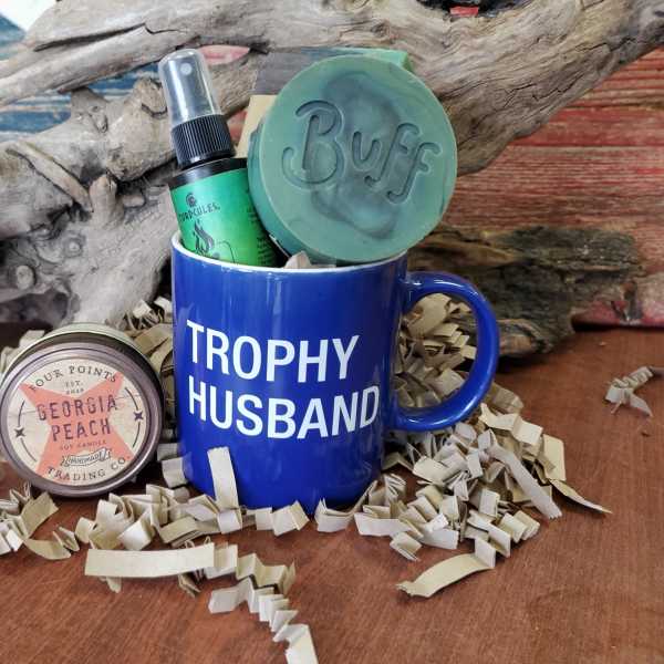 Gift mug with candle and soap on shredded paper filler