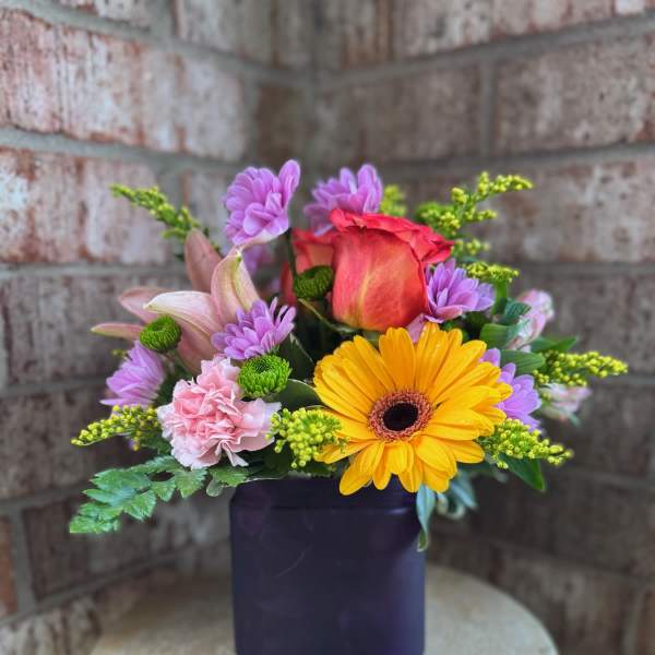 Mixed bouquet in a dark square vase with a yellow gerbera and pink rose
