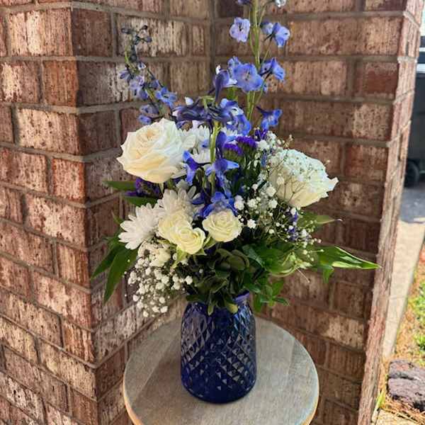 Blue and white floral arrangement in a cobalt vase