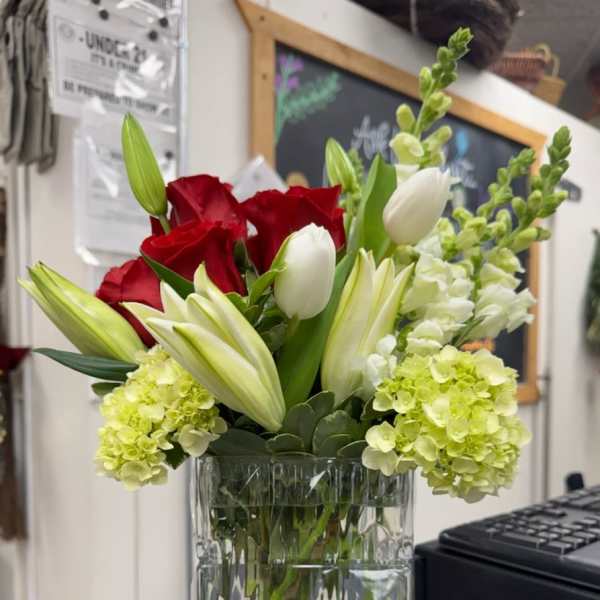 Red roses and white tulips in a clear glass vase